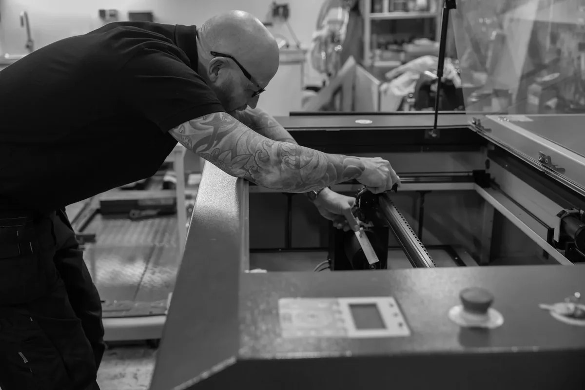 Werkzaamheden aan de lasergraveermachine in de werkplaats van Snake Designs.