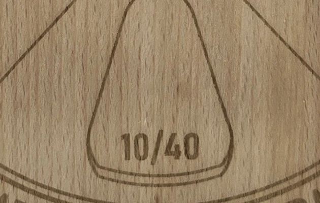 Close-up of the laser-engraved number 10/40 and wheel design on an AutoTek serving board.