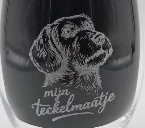 Close-up of the dachshund engraving and the words mijn teckelmaatje on a drinking glass for Druiventros.