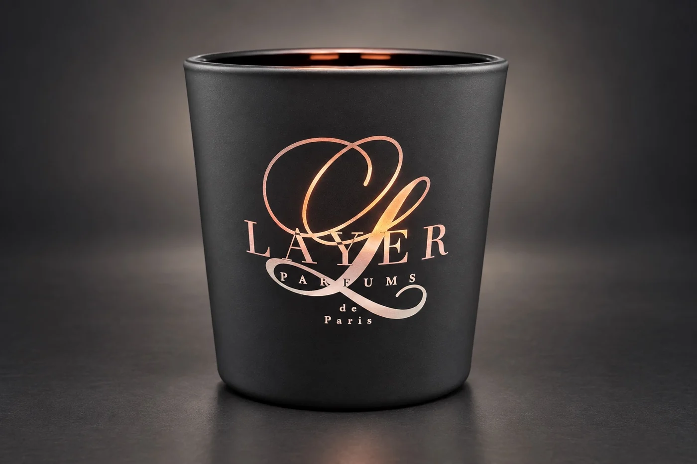 Matzwarte geurkaars met een sierlijk gegraveerd Layer Parfums-logo
