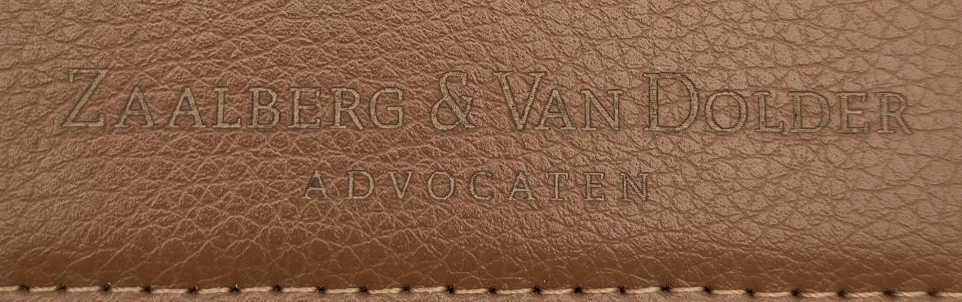 Close-up of the fine Zaalberg & Van Dolder Advocaten logo engraving on the textured brown PU surface