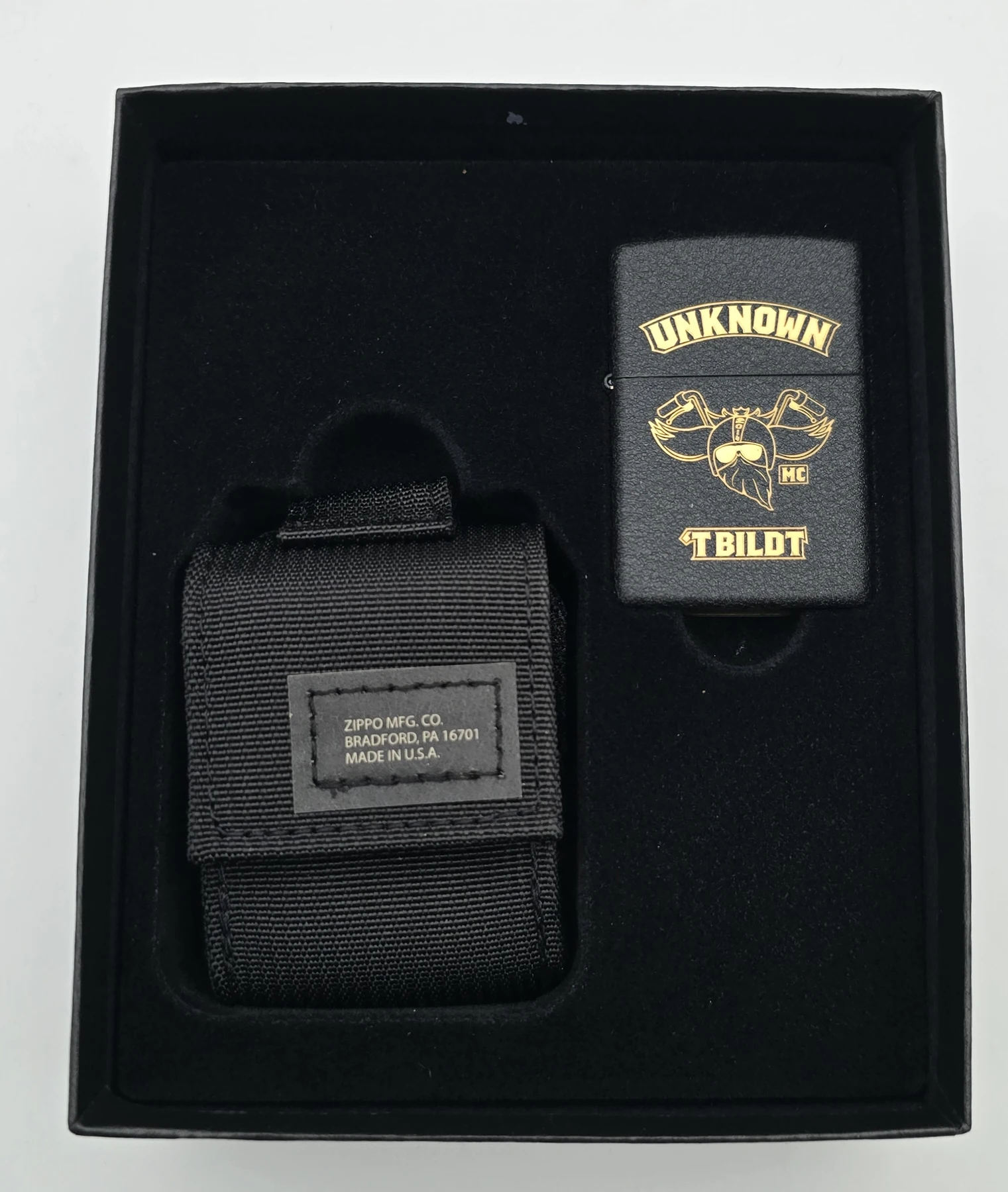 The engraved black Zippo and black pouch in the gift box