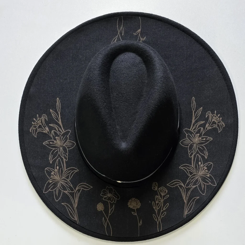 Engraved felt hat for The Fireflies with floral linework on the black brim